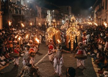 Kandy Esala Perahera nighttime procession with traditional Kandyan dancers, drummers, torchbearers and ceremonial elephants in Kandy, Sri Lanka.