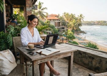 Digital nomad working remotely on a laptop at an open air café on Sri Lanka’s tropical south coast.