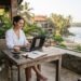 Digital nomad working remotely on a laptop at an open air café on Sri Lanka’s tropical south coast.